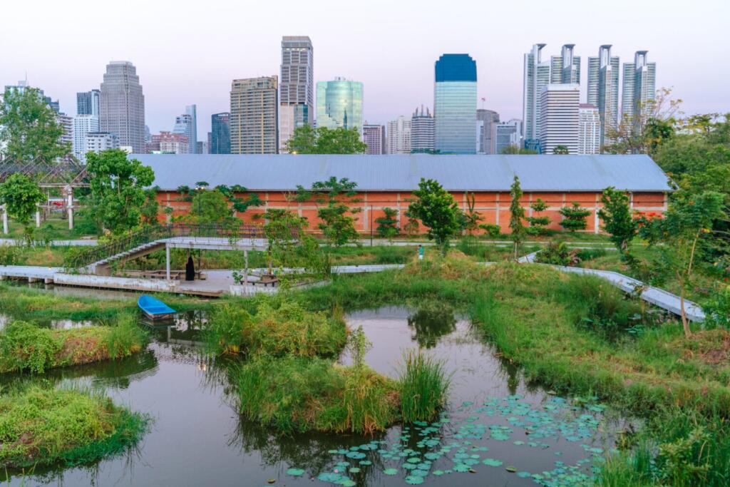 Wetland landscape at Benjakitti Park with restored industrial building and Bangkok skyline