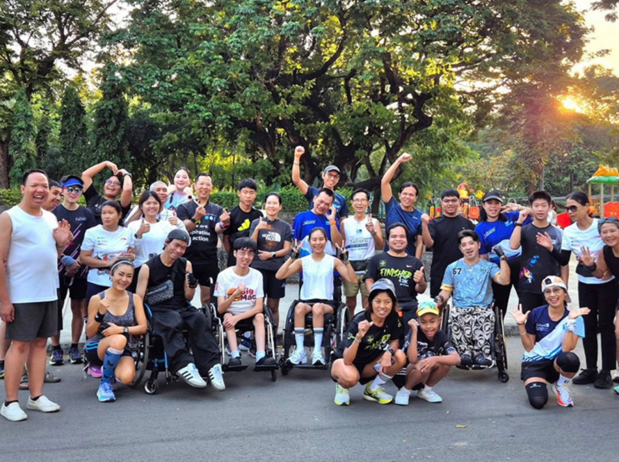 People with and without disabilities participate together in a community physical activity event in a public park.